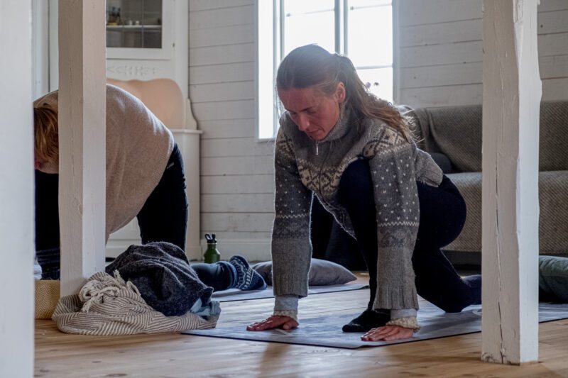 Kvinna i Yinyoga position under Wise Woman Retreat i Järvsö. Hon har händerna i golvet och står på ett knä. 